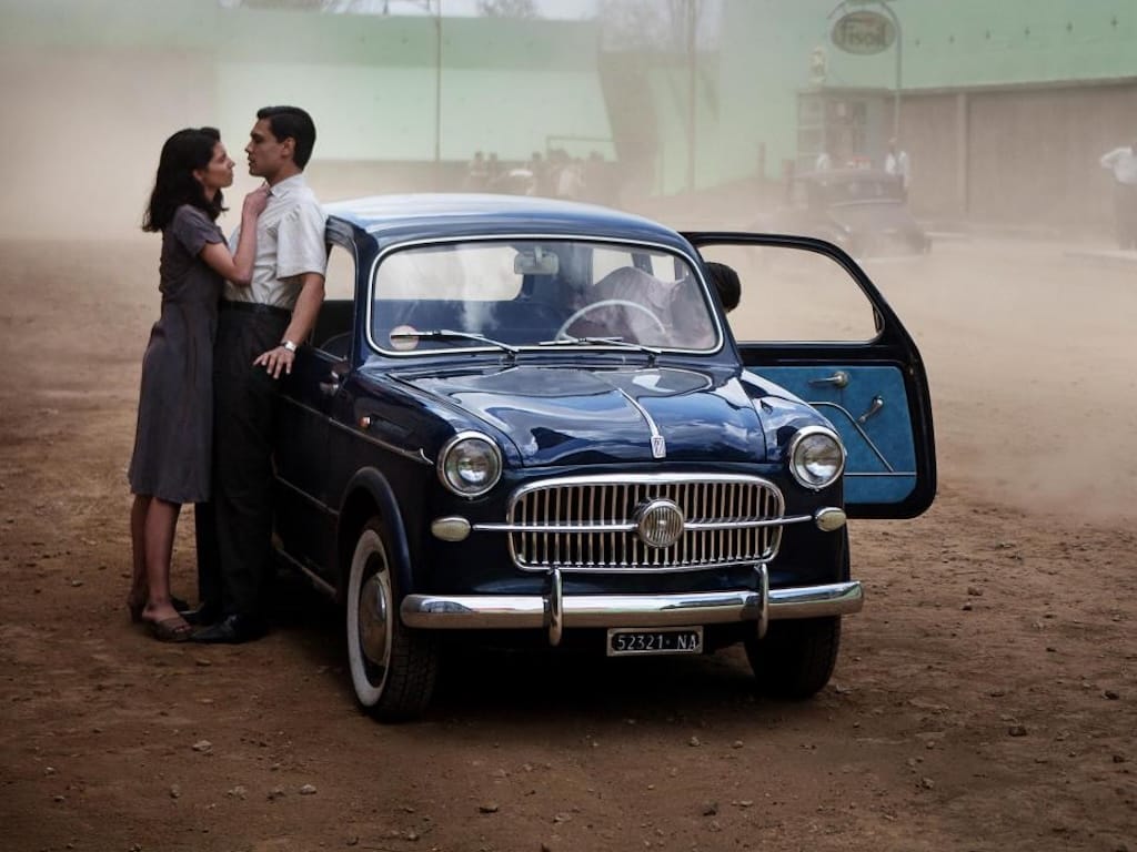 Lila pushes Marcello against his Fiat in a menacing way.